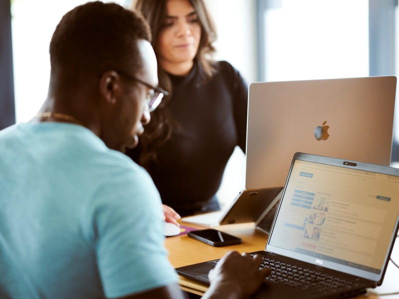 zwei Personen an Laptops