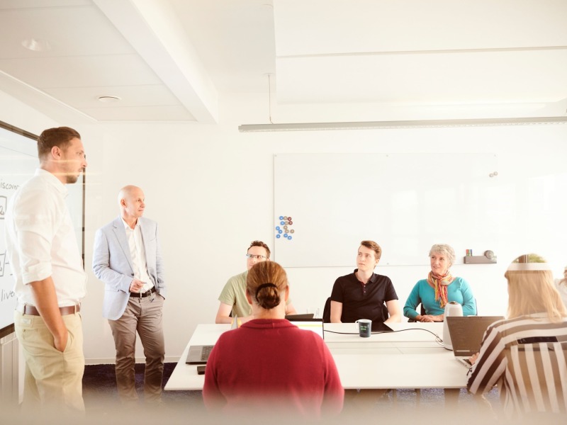 zwei meschen am Konferenztisch mit Laptops