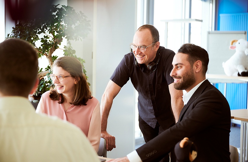 Mitarbeitende in einer Unterhaltung im Büro